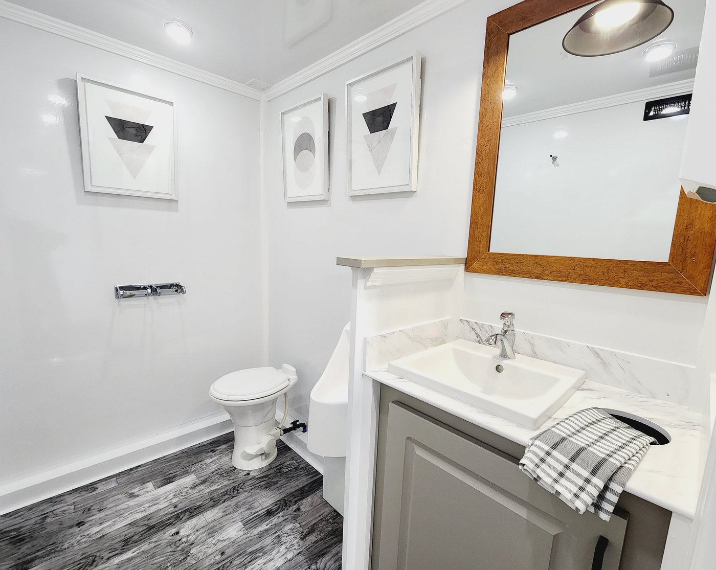 Men's suite with porcelain toilet, waterless urinal, and marble vanity